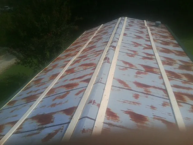 Rusted metal roof panels with new wood purlins before replacement — Storm Damage Roof Repair in Walling by Roofing Brothers