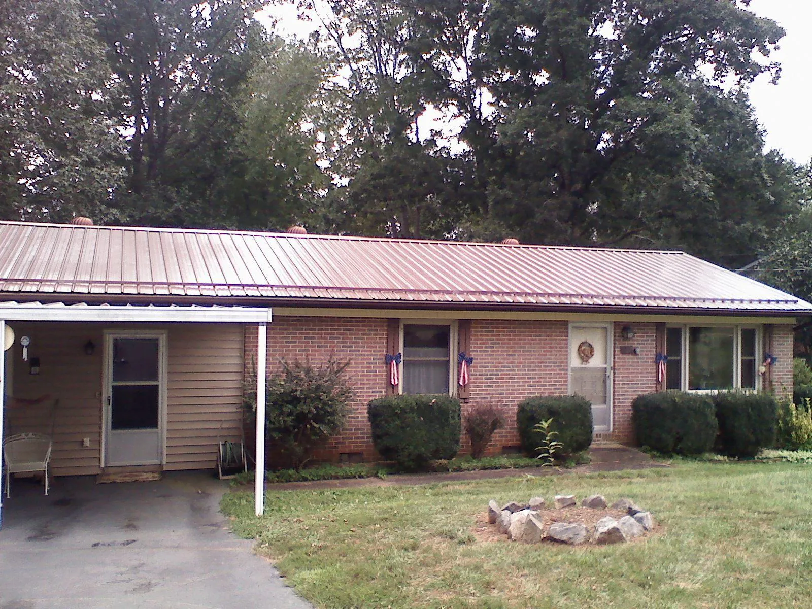 Bronze metal roof and carport on a brick ranch home — Roof Repair work by our crew in Walling