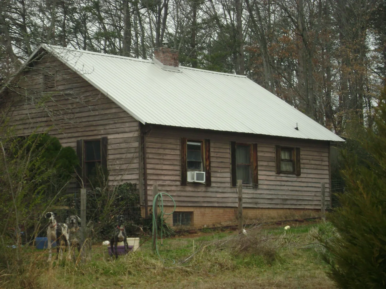 White metal roof on an old wood sided farmhouse, from a Metal Roof Installation job in Walling